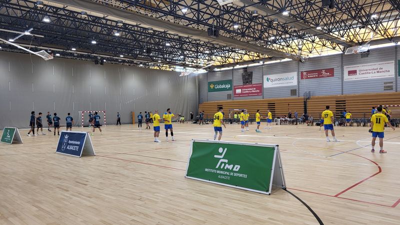 Jugadores de ambos equipos calentando sobre la pista antes del partido